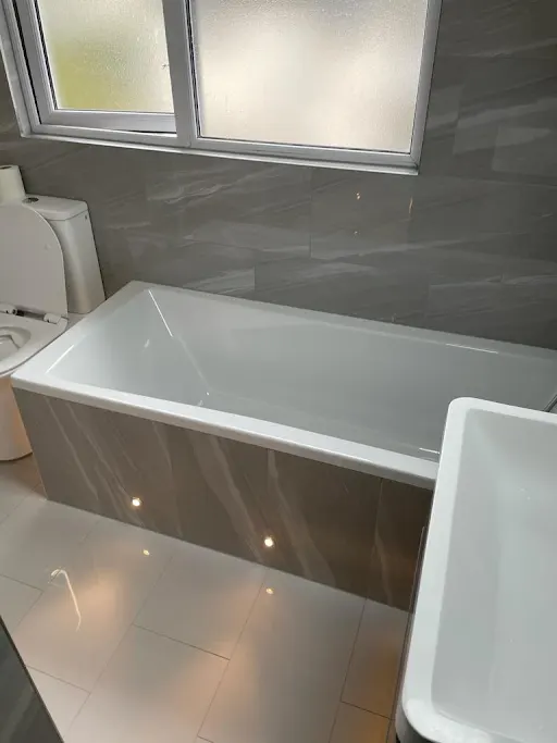 Bathroom renovation with panelled bath and marble-effect tiling, Bexley